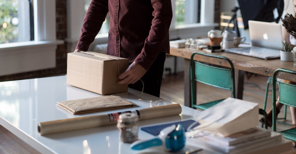 person packing a box on a desk