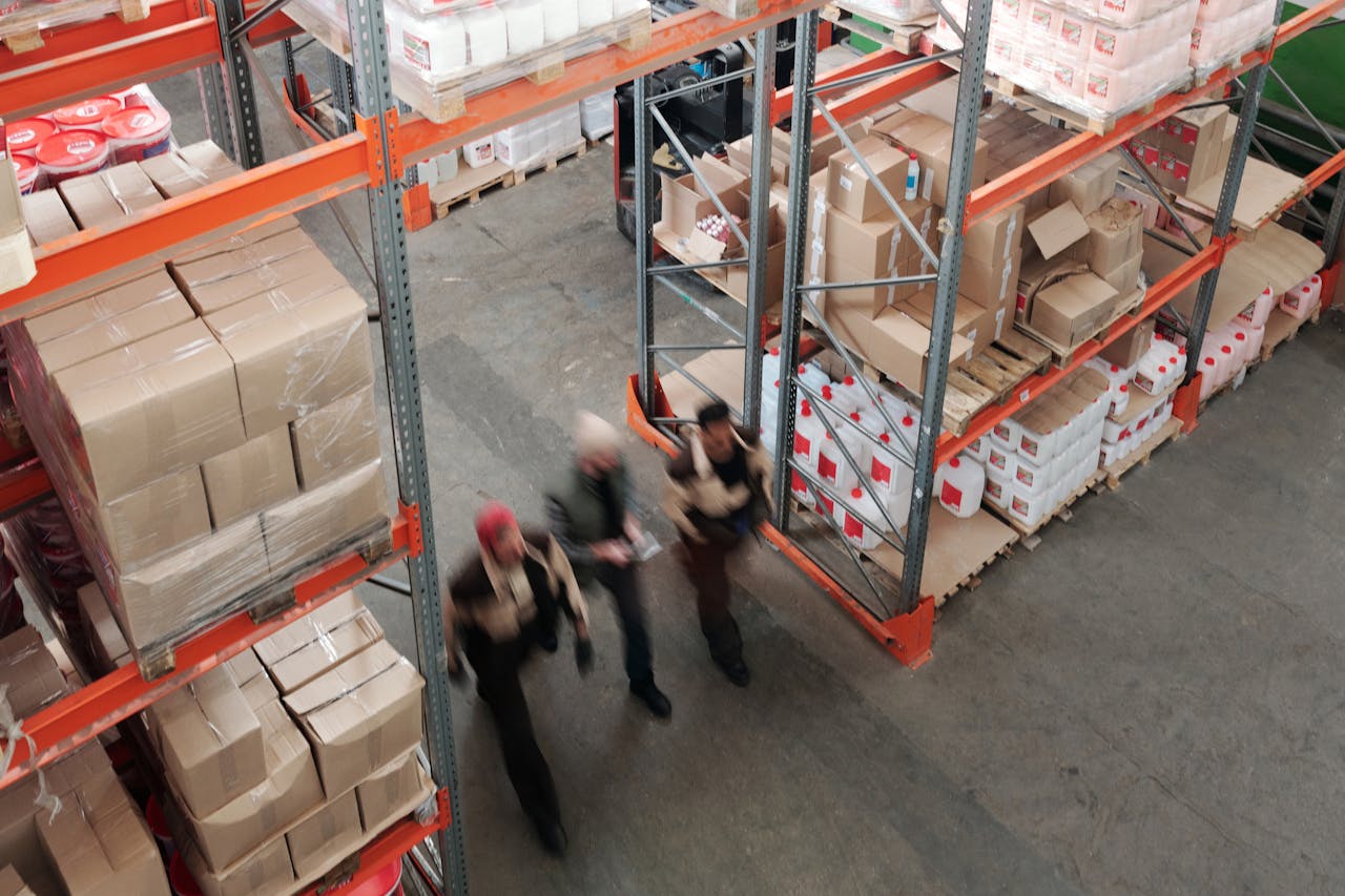 3 people walking in a warehouse